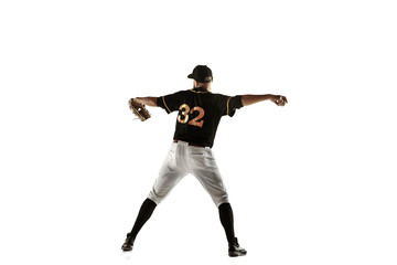 Baseball player, pitcher in a black uniform practicing and training isolated on a white background. Young professional sportsman in action and motion. Healthy lifestyle, sport, movement concept.