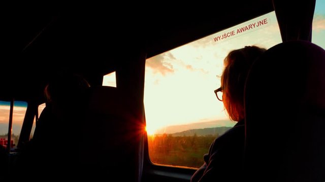 Girl watching the sunrise in marshrutka bus while traveling, Georgia