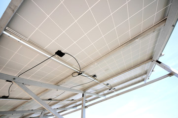 Close up of underside of solar panel installation with a blue sky background