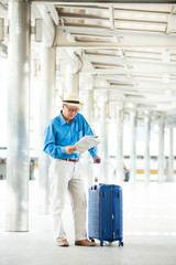 Senior man traveling with luggage checking city map and sightseeing. Senior man Travel and tourism concept.