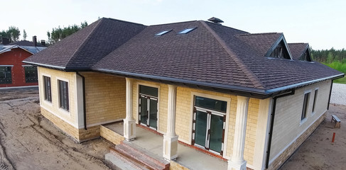 Bituminous tile for a roof. House with a roof from a bituminous tile. a roof from a bituminous tile. Moder