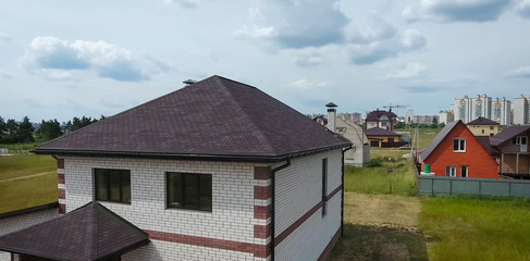 Bituminous tile for a roof. House with a roof from a bituminous tile. a roof from a bituminous tile. Moder