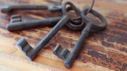 Old iron keys close-up lies on an old wooden table.