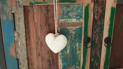 White wooden heart on the old wooden multi-colored cupboard  background. Love, wedding and Valentine's Day concept 