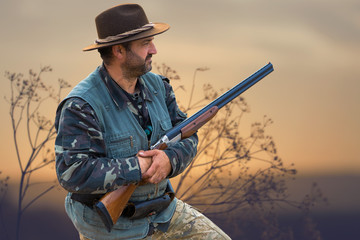 Hunting period, autumn season open. A hunter with a gun in his hands in hunting clothes in the...