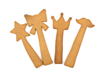 Homemade gingerbread cookies: star, bow, crown and moustache on a stick isolated on a white background.