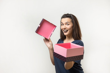 Portrait of a happy smiling girl opening a gift box isolated over white background