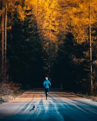 Foto auf Acrylglas Antireflex Runner training on the road in beautiful autumn nature. Orange trees all around © kovop58