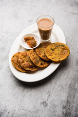 Methi Poori or Puri made using Fresh fenugreek leaves missed with wheat flour, by making small pancake size shapes deep fried in oil, served with tea