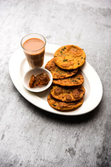 Methi Poori or Puri made using Fresh fenugreek leaves missed with wheat flour, by making small pancake size shapes deep fried in oil, served with tea