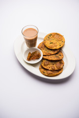 Methi Poori or Puri made using Fresh fenugreek leaves missed with wheat flour, by making small pancake size shapes deep fried in oil, served with tea