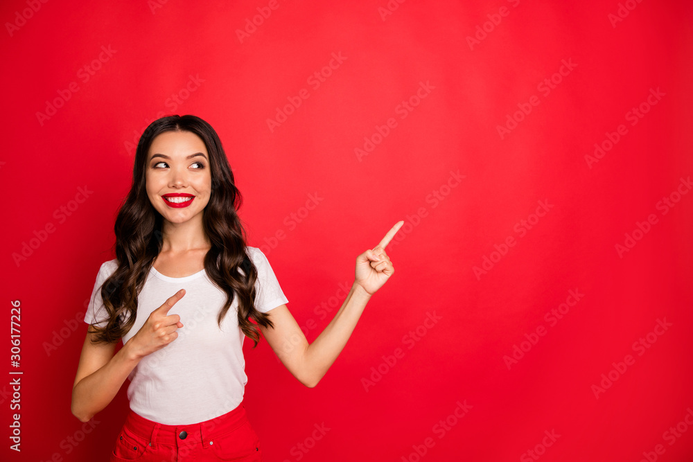 Wall mural Portrait of her she nice gorgeous winsome glamorous attractive lovely cheerful cheery wavy-haired girl pointing copy space ad isolated over bright vivid shine vibrant red color background