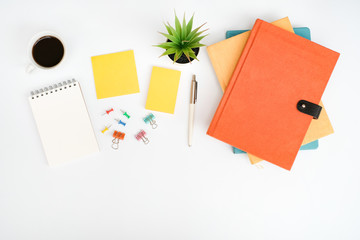 Work space office table desk with blank notepad and sticky note, stack of book and supplies, Top view with copy space, flat lay business office concept