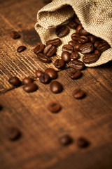Kaffeebohnen mit Beutel auf Holztisch vertikal