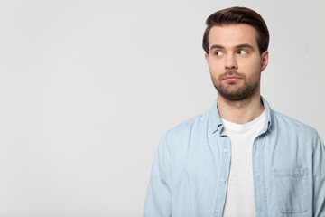 Serious Caucasian man look aside at blank copy space