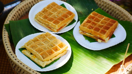 Myanmar waffles with syrup on banana leaf background