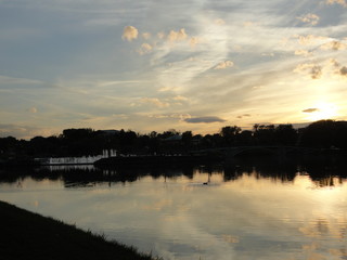 Obraz premium river at sunset, clouds reflected in the water