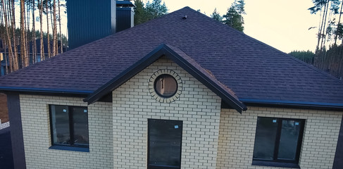 Bituminous tile for a roof. House with a roof from a bituminous tile. a roof from a bituminous tile. Moder