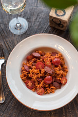 Fototapeta premium Red Fusilli Pasta with Sausages, Fresh Tomatoes and Tomato Sauce