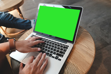 A man is working using laptop at coffee shop, blank green screen for background.