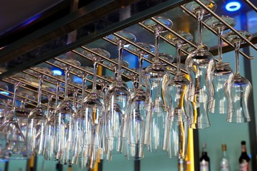 Wine and champagne empty glasses hanging above the bar counter.