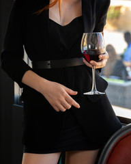 girl in a black dress with a glass of red wine