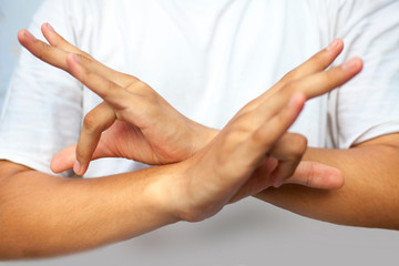 Isolated hands of male teenager doing Bhutadamar Yoga Mudra/ Shuni Yoga mudra wearing a white...