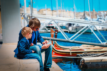 father and little son looking at map on the quay of Valetta, Malta