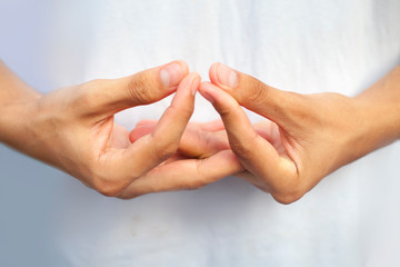 Isolated hands of teenage boy doing Mida-no Jouin Yoga Mudra on a white background by interlacing...