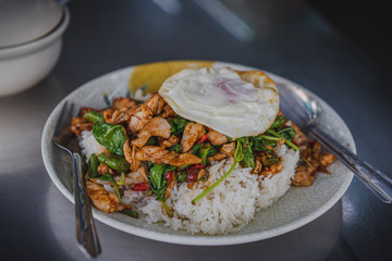 Thai rice topped with stir-fried pork hot chilli and basil with cabbage and fried egg.	