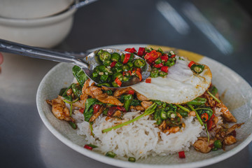 Thai rice topped with stir-fried pork hot chilli and basil with cabbage and fried egg.	