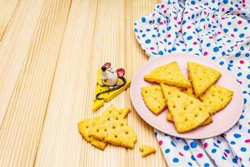 Funny kids cookies. Festive cheese crackers, New Year snack concept. Food, mouse sculpture, napkin. Wooden planks background
