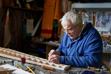 Senior man who makes the wing of a radio-controlled aircraft, the construction of the airplane.
