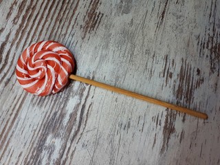  close-up of sweet fruit lollipop on abstract wooden surface background