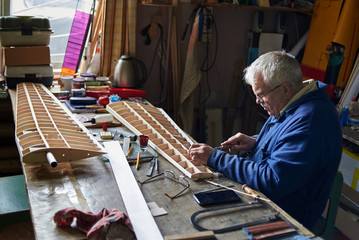 Senior man who makes the wing of a radio-controlled aircraft, the construction of the airplane.