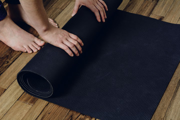 Close-up of young woman rolling her fitness mat