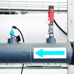 Large industrial water treatment and boiler room. Shiny steel metal pipes and switches