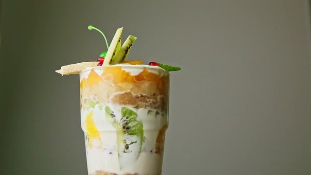 closeup layered fruit cream dessert in tall glass spinning around