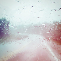 Water on the windshield of car, with view of road with effects