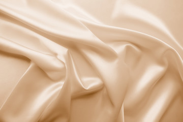 Fototapeta premium Beautiful smooth elegant wavy beige / light brown satin silk luxury cloth fabric texture, abstract background design. Copy space. Card or banner