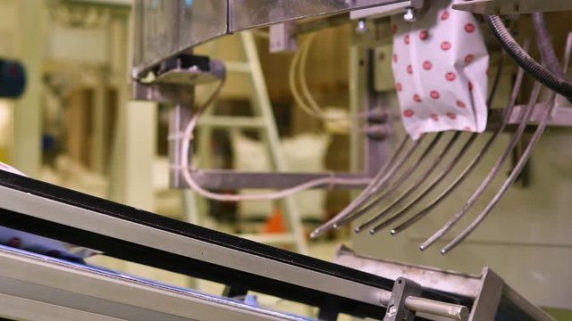 White plastic food bags falling on a conveyor belt in a bakery factory 