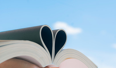  Open book with curled leaves in the shape of a heart.