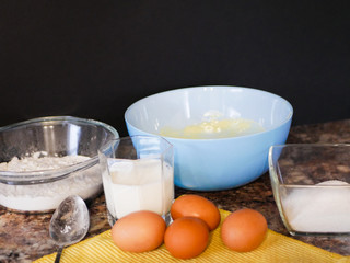 flour, eggs, milk. Baking ingredients. Spoon on a marble table. Preparation for cooking.
