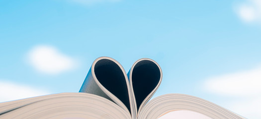  Open book with curled leaves in the shape of a heart.