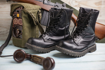 Botas militares de cuero negro junto a una radio militar 