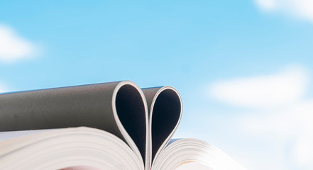  Open book with curled leaves in the shape of a heart.