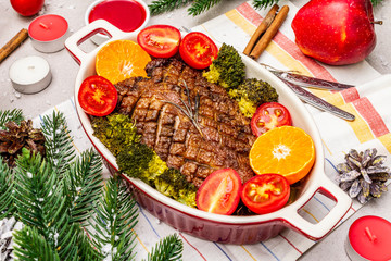 Baked duck breast on the bone with vegetables and sauce. Christmas dinner concept, New Year table setting. Stone concrete background