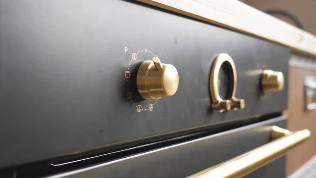 Woman Turning On Vintage Oven, Closeup View