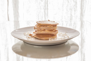 Foie gras with gelatin on a white plate, white table and white curtain