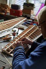 Senior man makes the wing of a radio-controlled aircraft, the construction of the airplane.
